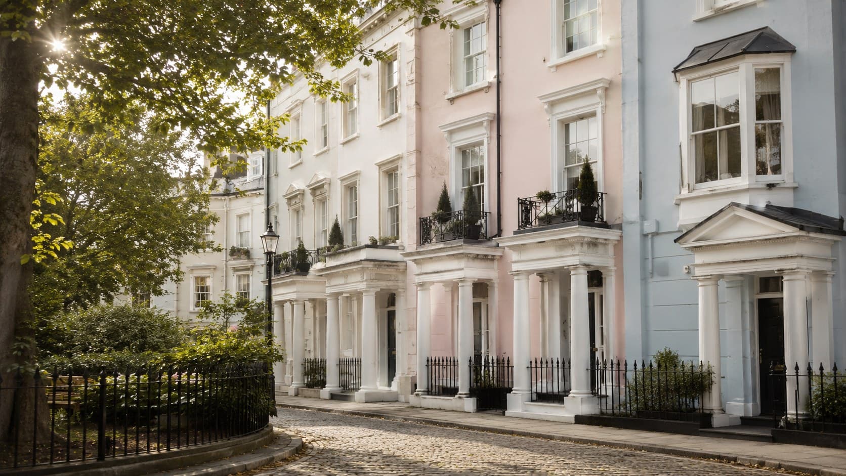 A quiet row of pastel stucco townhouses in Notting Hill, London